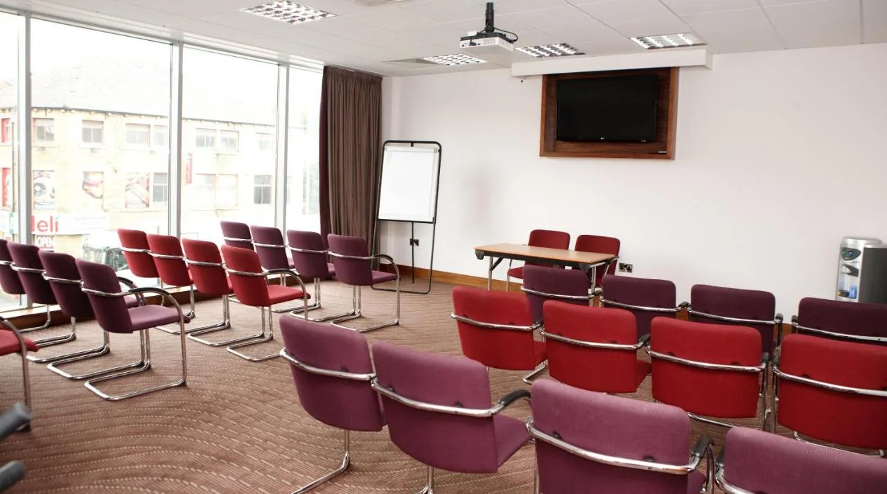 a room with chairs and a table and a screen at Leonardo Hotel Belfast in Belfast