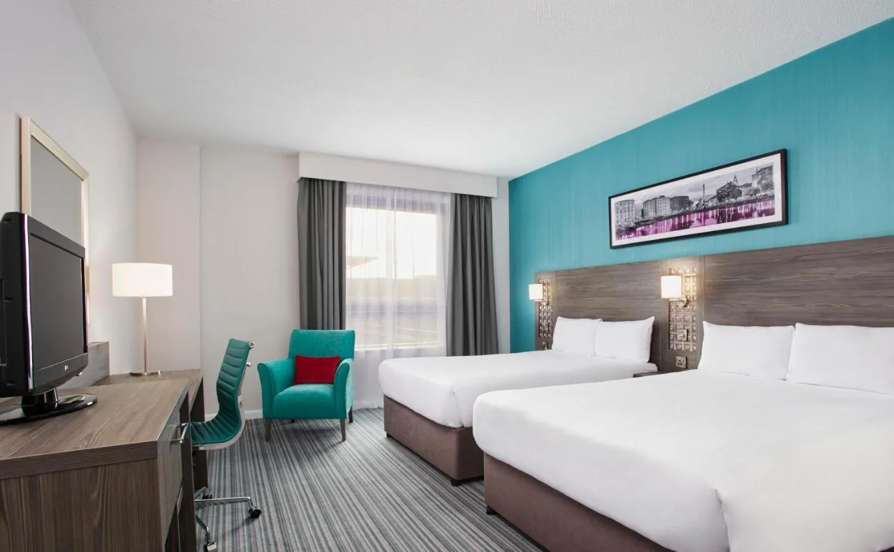 a hotel room with two beds and a television at Leonardo Hotel Belfast in Belfast